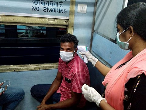 Thermal screening of a passenger being done inside a train to check the spread of coronavirus in Thiruvananthapuram on Monday.