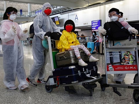 Passengers wear protective suits, amid the outbreak of coronavirus, at Hong Kong International Airport on March 17, 2020.