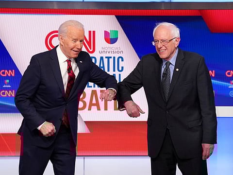 Democratic US presidential candidates former Vice President Joe Biden and Senator Bernie Sanders do an elbow bump in place of a handshake as they greet other before the start of the 11th Democratic candidates debate of the 2020 US presidential campaign, held in CNN's Washington studios without an audience because of the global coronavirus pandemic, in Washington, on March 15, 2020.