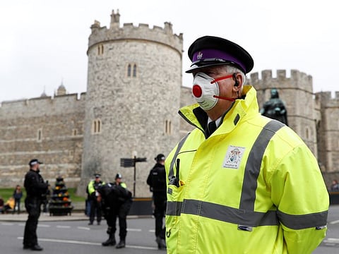 A security guard wearing a face mask stands outside Windsor Castle as the number of coronavirus cases grow around the world, on March 17, 2020.