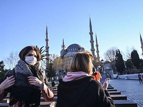 Women wear protective face masks near Sultanahmet Mosque also known as the Blue Mosque as the nation tries to contain the novel coronavirus, COVID-19, in Istanbul on March 17, 2020.