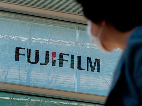 A pedestrian walks past the headquarters for Fujifilm Holdings in Tokyo.