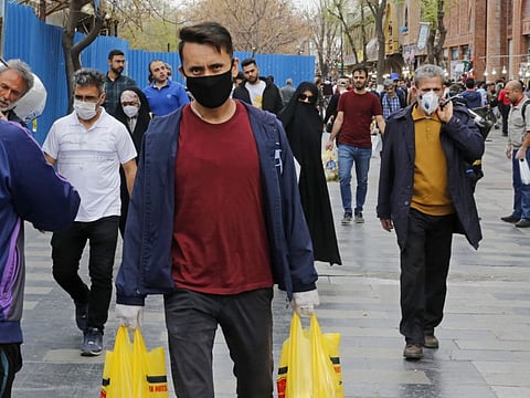 Iranians, some wearing protective masks,walk outside the capital Tehran's grand bazaar, during the Covid-19 coronavirus pandemic crises, on March 18.