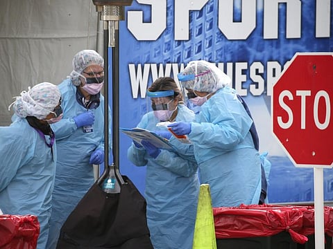 Medical personnel process a sample taken from a patient during a COVID-19 screening at an appointment-only drive-up clinic set up by the University of Washington Medical Center Northwest Outpatient Medical Center on March 17, 2020 in Seattle, Washington