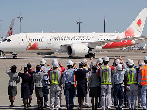 Airline ground staff gives a send-off to the aircraft that will carry the Olympic torch upon its departure for Greece at Tokyo's Haneda Airport on Wednesday. Japan decided not to send a delegation to the Olympic flame handover ceremony in Greece later this week due to Coronavirus concerns.