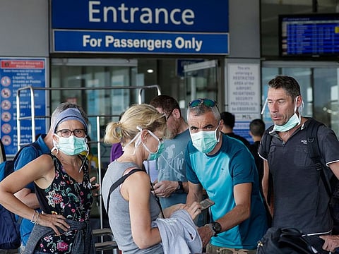 Foreigners wearing protective masks prepare to enter the departure area of Manila's International Airport, Philippines.