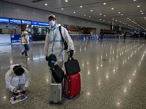 Passengers wearing protective gear, amid concerns of the COVID-19 coronavirus, stand in the arrivals area at Shanghai Pudong International Airport in Shanghai in March 18, 2020.