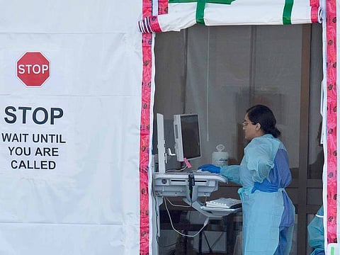 A hospital worker is seen at a staff COVID-19 assessment area outside Lions Gate Hospital in North Vancouver, British Columbia, Wednesday, March 18, 2020.