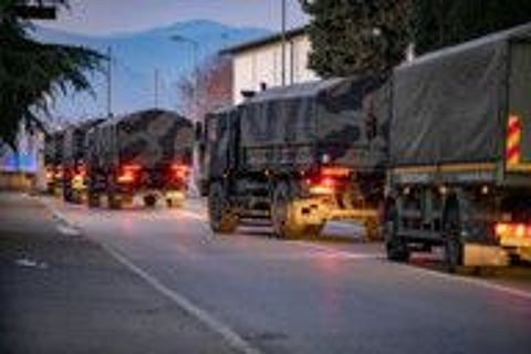 Italian military trucks drive through streets of Bergamo after the army were deployed to move coffins from the town.