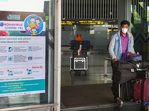 A masked passenger pushes a luggage trolley at NSCBI airport, in Kolkata, on Thursday, March 19, 2020.