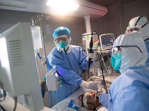 Medical staff treat a COVID-19 coronavirus patient at a hospital in Wuhan, in China's central Hubei province on March 19, 2020. China on March 19 reported no new domestic cases of the coronavirus for the first time since it started recording them in January, but recorded a spike in infections from abroad.