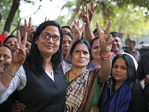 Asha Devi, center, mother of the victim of the fatal 2012 gang rape on a moving bus, displays a victory sign with her lawyer after the rapists of her daughter were hanged in New Delhi, India, Friday, March 20, 2020.