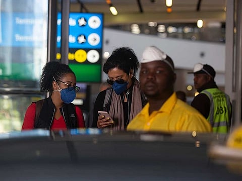 Travellers wear masks as they walk through O.R. Tambo airport in Johannesburg, South Africa.