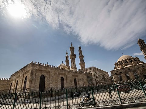 A few people walk in the vicinity of the closed Al-Azhar mosque in Egypt's capital Cairo on March 20, 2020, after the country's Muslim religious authorities decided to put the Friday prayers on hold, in order to avoid gatherings and the spread of the novel coronavirus COVID-19 disease.  / AFP / Khaled DESOUKI
