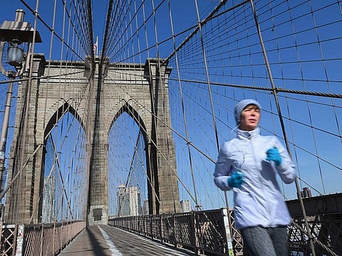 A solitary jogger crosses the Brooklyn Bridge on March 18, 2020 in New York City.