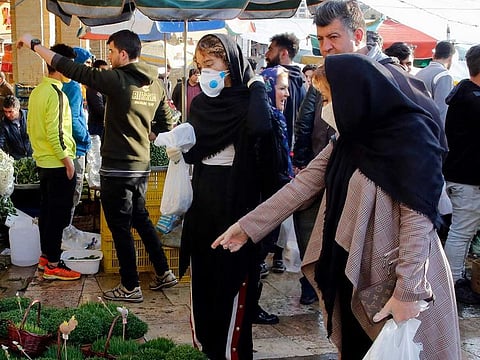 Iranians, some wearing masks to protect against the novel coronavirus, choose green sprouts as part of the seven traditional items set on a table, ahead of Nowruz, the national New Year two-week celebration, at the Tajrish Bazaar in the capital Tehran on March 19, 2020.