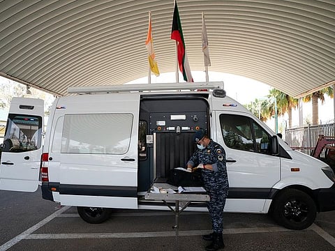 A Kuwait Ministry of Interior Special Forces officer checks a bag following coronavirus disease (COVID-19) outbreak at Khairan Resort, used as a quarantine centre in Khairan, Kuwait March 19, 2020.