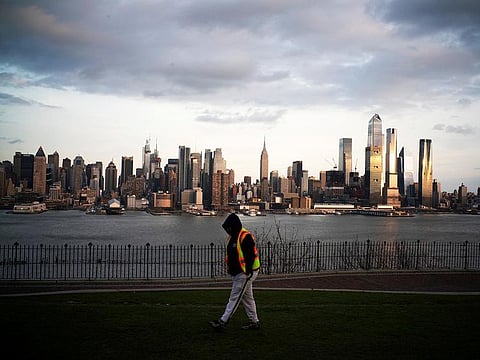 The Empire State Building and the skyline of New York are seen while a man walks around a local park in Weehawken, New Jersey, as the coronavirus disease (COVID-19) outbreak continues in New York, U.S., March 22, 2020.