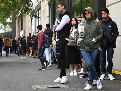 Hundreds of people queue outside an Australian government welfare centre, Centrelink, in Melbourne on March 23, 2020,