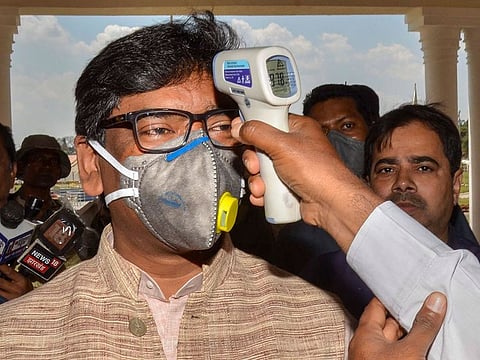 An official uses a thermal screening device on Jharkhand CM Hemat Soren in the wake of coronavirus pandemic as he arrives during the ongoing budget session of Jharkhand Assembly, in Ranchi, Monday, March 23, 2020.