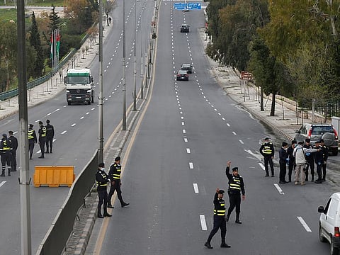 Jordanian police personnel guard at a checkpoint during the second day of a nationwide curfew, amid concerns over the coronavirus disease (COVID-19) spread, in Amman
