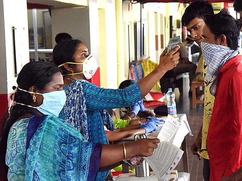 File photo: Medical officers measure body temperature of passengers at a railway station in Kochi.