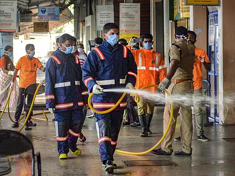 Kozhikode: Workers spray disinfectant in the premises of KSRTC bus stand to contain the spread of coronavirus, in Kozhikode, Monday, March 23, 2020