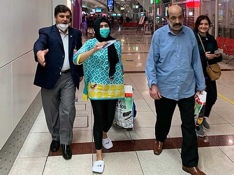 Pakistan Consul General Ahmed Amjad Ali (left) leading the stranded passengers to the special flight at the Dubai International Airport on Monday night.