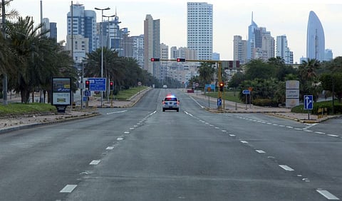 A Kuwaiti police car patrols deserted streets in Kuwait city, on March 23, a day after authorities declared a nationwide curfew amid the COVID-19 pandemic.
