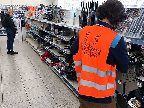 Employees of the Action supermarket wear a safety vest asking customers to keep 1.5 metres safe distance, in Amsterdam, on Tuesday, March 24, 2020. A new study has found that quarantining infected people and their family members, closing schools, and imposing workplace distancing and homeworking can all limit the spread of COVID-19.