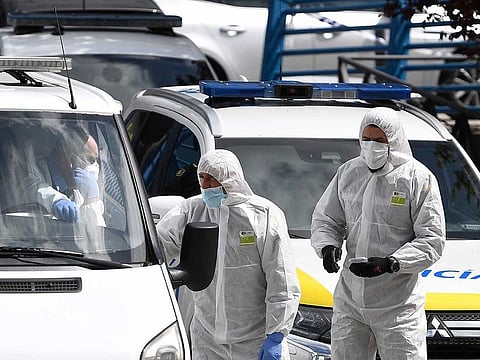 Members of the Spanish Army's Military Emergency Unit (UME) wearing protective suits talk to undertakers driving a van outside the the Palacio de Hielo (Ice Palace) shopping mall where an ice rink was turned into a temporary morgue on March 24, 2020 in Madrid to deal with a surge in deaths in the Spanish capital due to the coronavirus.