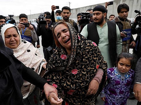 An Afghan Sikh woman mourns for her relatives near the site of an attack in Kabul, Afghanistan on Wednesday.