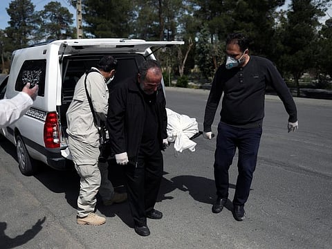 Iranian men carry the coffin of the journalist Abdollah Zavieh, who passed away due to coronavirus disease (COVID-19), to bury him at Behesht Zahra cemetery in Tehran on March 24.