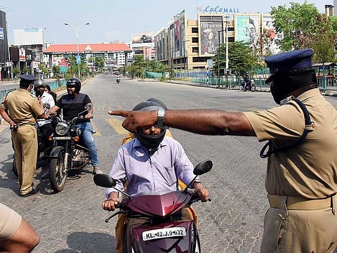 Police personnel stop commuters during lockdown to contain the spread of COVID-19, in Kochi on Tuesday.