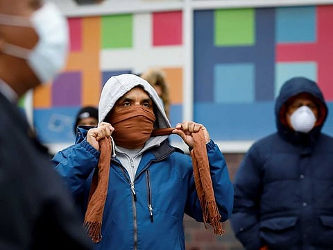 People wait in line to be tested for coronavirus disease (COVID-19) while wearing protective gear, outside Elmhurst Hospital Center in the Queens borough of New York City on March 25, 2020.