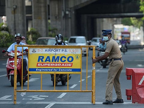 A policeman sets a barrier at a roadblock during the first day of a 21-day government-imposed nationwide lockdown as a preventive measure against the COVID-19 virus, in Chennai on March 25, 2020.