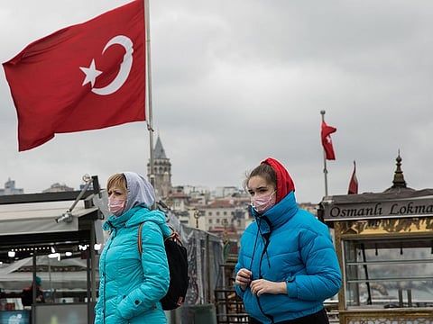 Tourists wearing pink colored protective face masks walk across Emimonu Square in Istanbul, Turkey, on Wednesday, March 25, 2020.