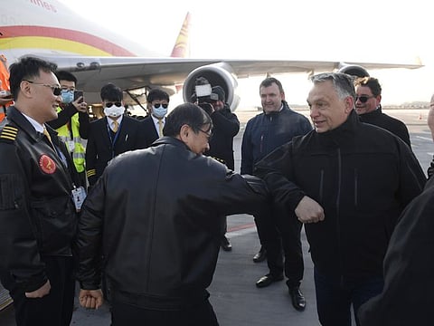 Hungarian Prime Minister Viktor Orban, second right, welcomes the staff of the Chinese Suparna Airlines at Liszt Ferenc International Airport in Budapest, Hungary, Tuesday, March 24, 2020. The delivery contains 3 million face masks, 100,000 tests and 86 ventilators to combat the COVID-19 coronavirus. In the centre Hungarian Minister of Innovation and Technology Laszlo Palkovics. (Tamas Kovacs/MTI via AP)