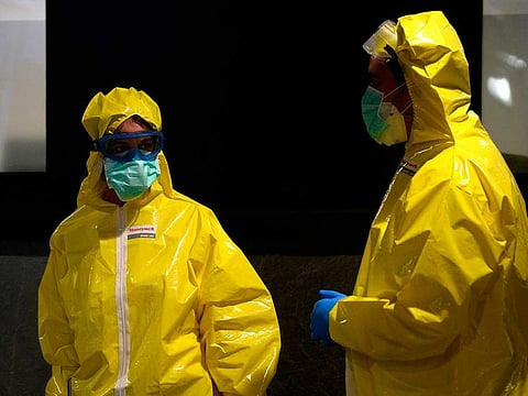 Paramedics wearing suits along with face masks and goggles as a protective measure against the COVID-19 coronavirus stand outside the Alvaro Cunqueiro hospital in Vigo, northwestern Spain, on March 25, 2020. As the global death toll soared past 20,000, Spain joined Italy in seeing its number of fatalities overtake China, where the virus first emerged just three three months ago.