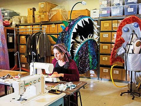 Corrina Bakken, the Minnesota Opera's costume director, sews masks for hospital workers in her office, Minneapolis, on March 24, 2020. With overrun hospitals facing an acute shortage of masks, people are pulling out their sewing machines to fill the void.