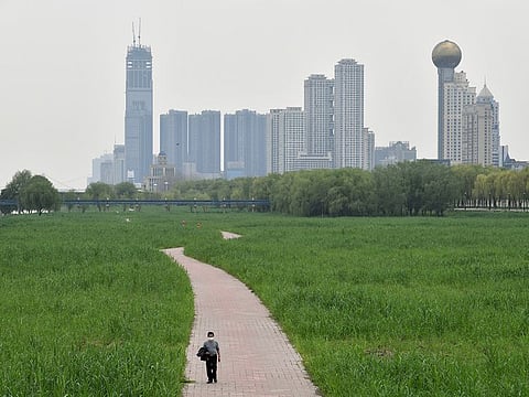 A man wearing a face mask walks at a riverside park in Wuhan of Hubei province, the epicentre of China's coronavirus disease (COVID-19) outbreak, March 26, 2020.