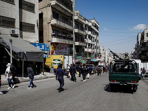A Jordanian soldier stands guard as people walk in the street after Jordan announced it would allow people to go on foot to buy groceries in neighbourhood shops, amid concerns over the spread of coronavirus disease (COVID-19), in Amman on March 25.