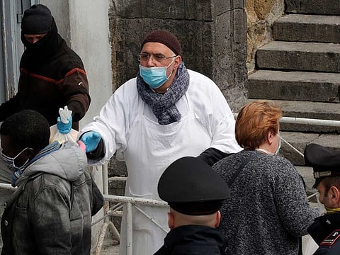 Priest Francesco wearing a face mask hands out a bag of food to homeless and poor people, as the spread of coronavirus disease (COVID-19) continues, in Naples, Italy, on March 27.