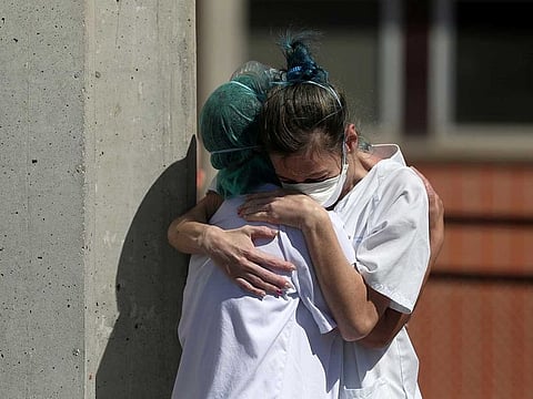 Medical wokers hug each other outside the emergency rooms at Severo Ochoa Hospital during the coronavirus disease (COVID-19) outbreak in Leganes, Spain, on March 26, 2020.