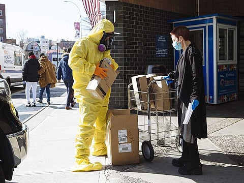 A person wearing protective clothing and a respirator mask donates protective equipment to the Elmhurst Hospital Center in the Queens borough of New York, US, on Thursday, March 26, 2020. New York City is the epicentre of the coronavirus pandemic in the United States, putting historic pressure on a world-renowned healthcare system as the number of confirmed cases in the area grows exponentially.