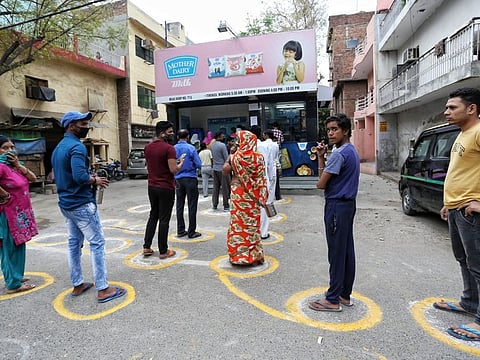 New Delhi, Mar 26 (ANI): People stand maintaining social distance outside a dairy to get milk and other essentials on the second day of the lockdown announced for the entire country in New Delhi on Thursday. (ANI Photo)