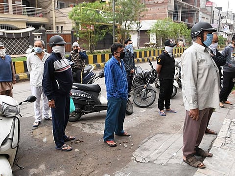 File picture: People wait for their turn to buy medicine outside a pharmacy in Amritsar, India, on March 28,2020.