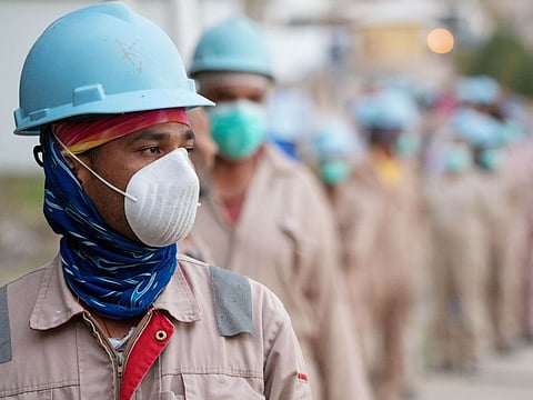 Labourers wear protective face masks as they wait in line to get temperature checked before entering construction worksite, following the outbreak of the coronavirus disease (COVID-19), in Ahmadi, Kuwait March 28, 2020. REUTERS/Stephanie McGhee TPX IMAGES OF THE DAY