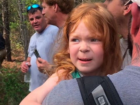 Rescuers carry 4-year-old Vadie Sides out of the woods in Lee County, Ala., Friday, March 27, 2020.