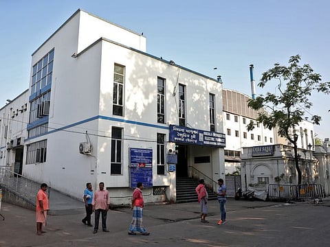 People stand outside Nimtala Crematorium, where a coronavirus positive patient Samir Kumar Mitra was cremated on March 23, in Kolkata.